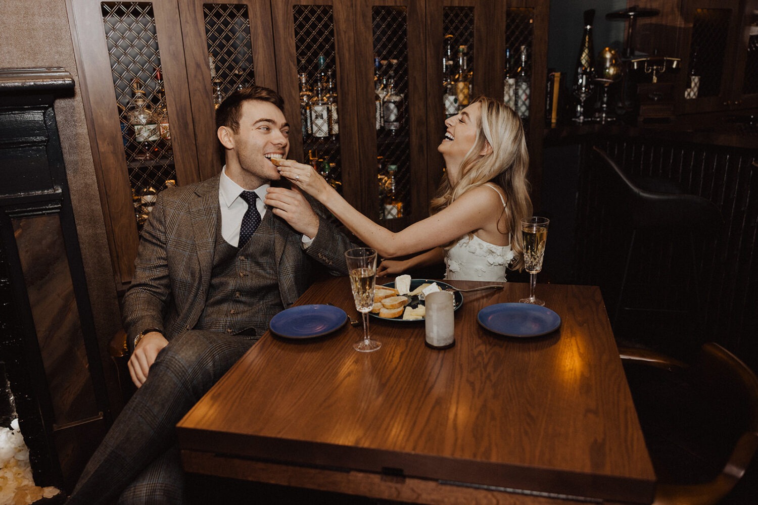 couple eats and drinks at bar engagement session 