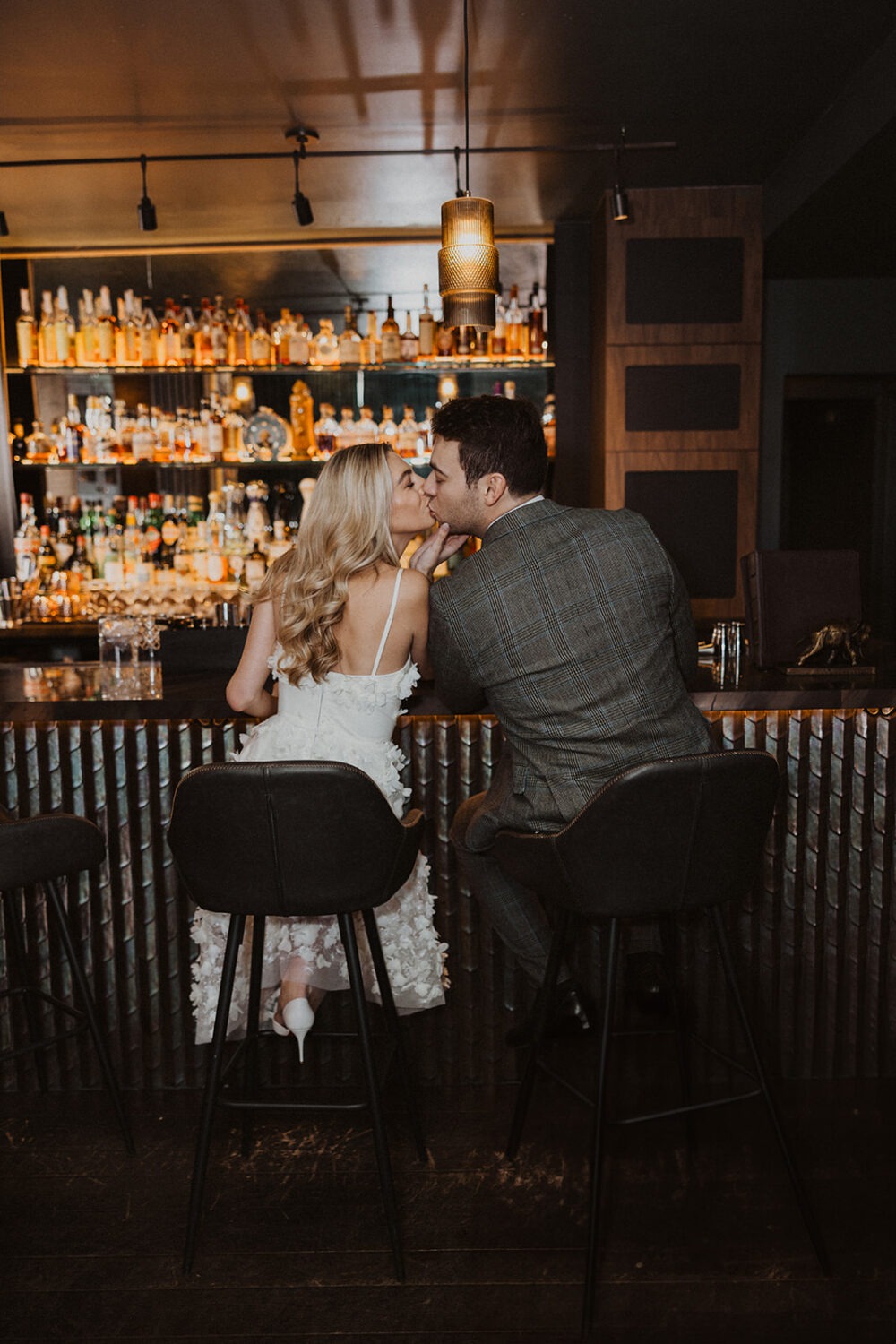 couple kisses at bar during cocktail bar engagement session 