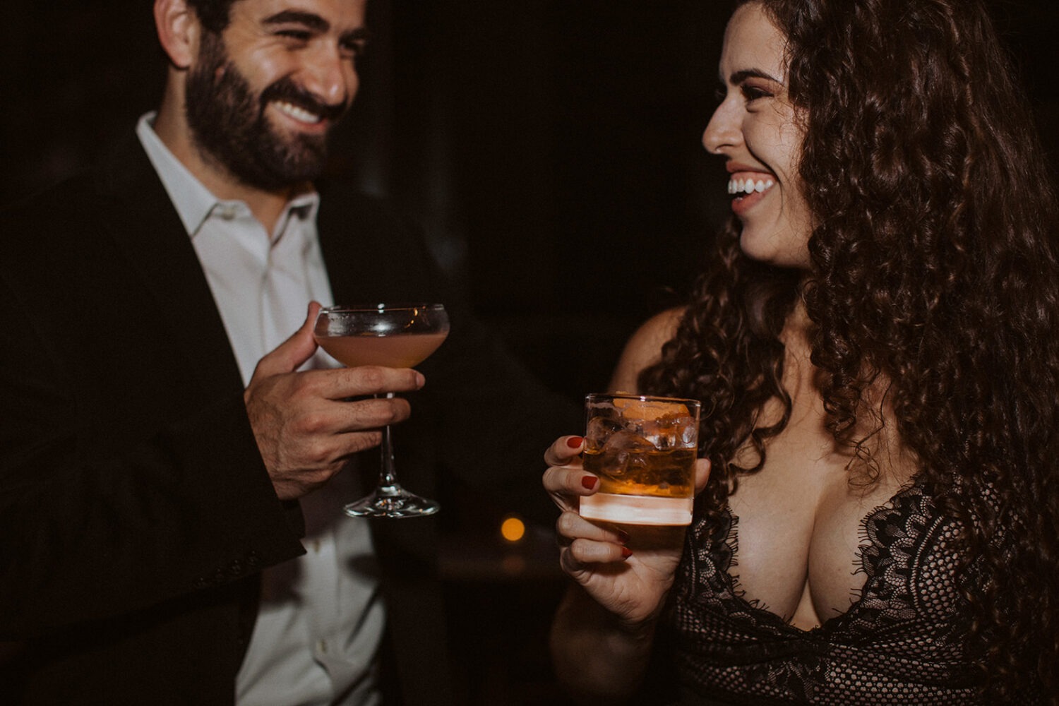 couple drinks cocktails laughing at engagement session 