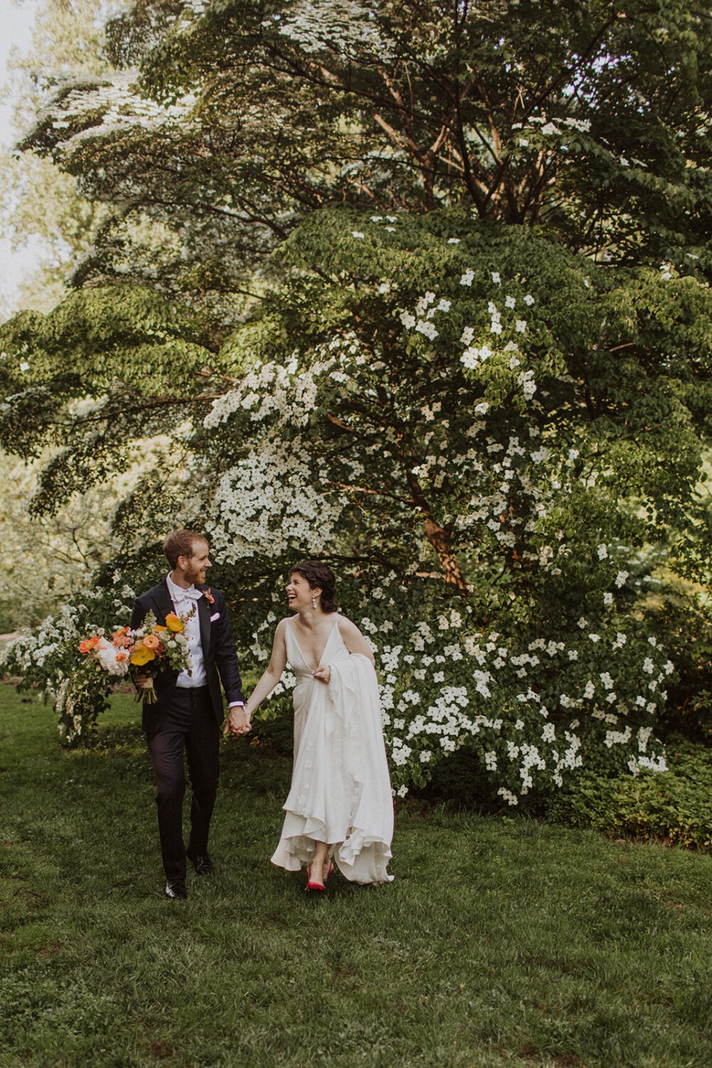 couple walks through forest at National Arboretum wedding