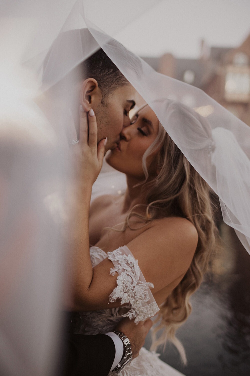 couple kisses under veil