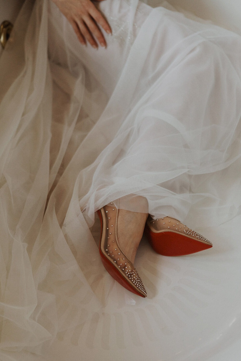 bride wears sparkling heels under white tulle wedding dress 