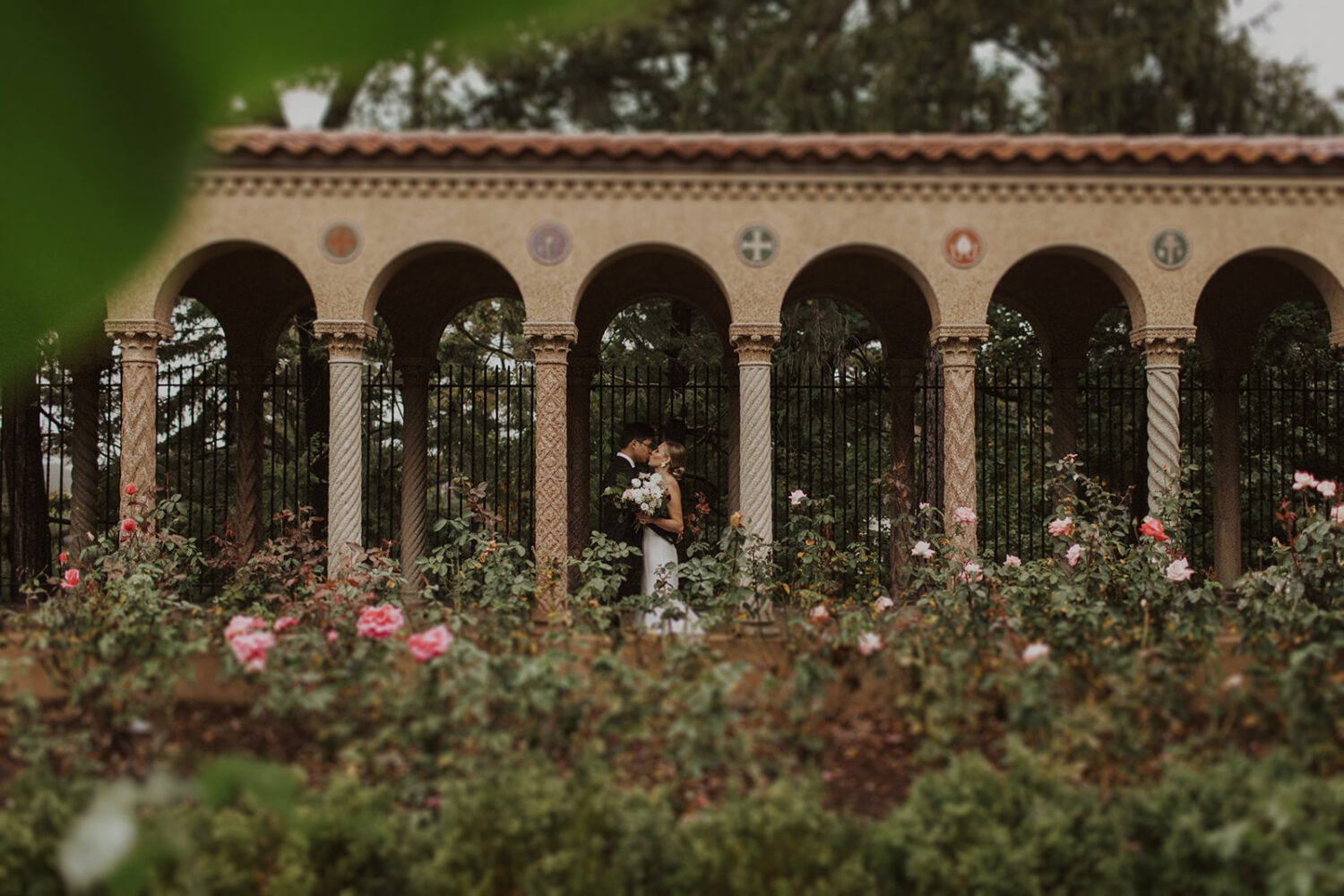 couple kisses in garden at St. Francis Hall & Gardens
