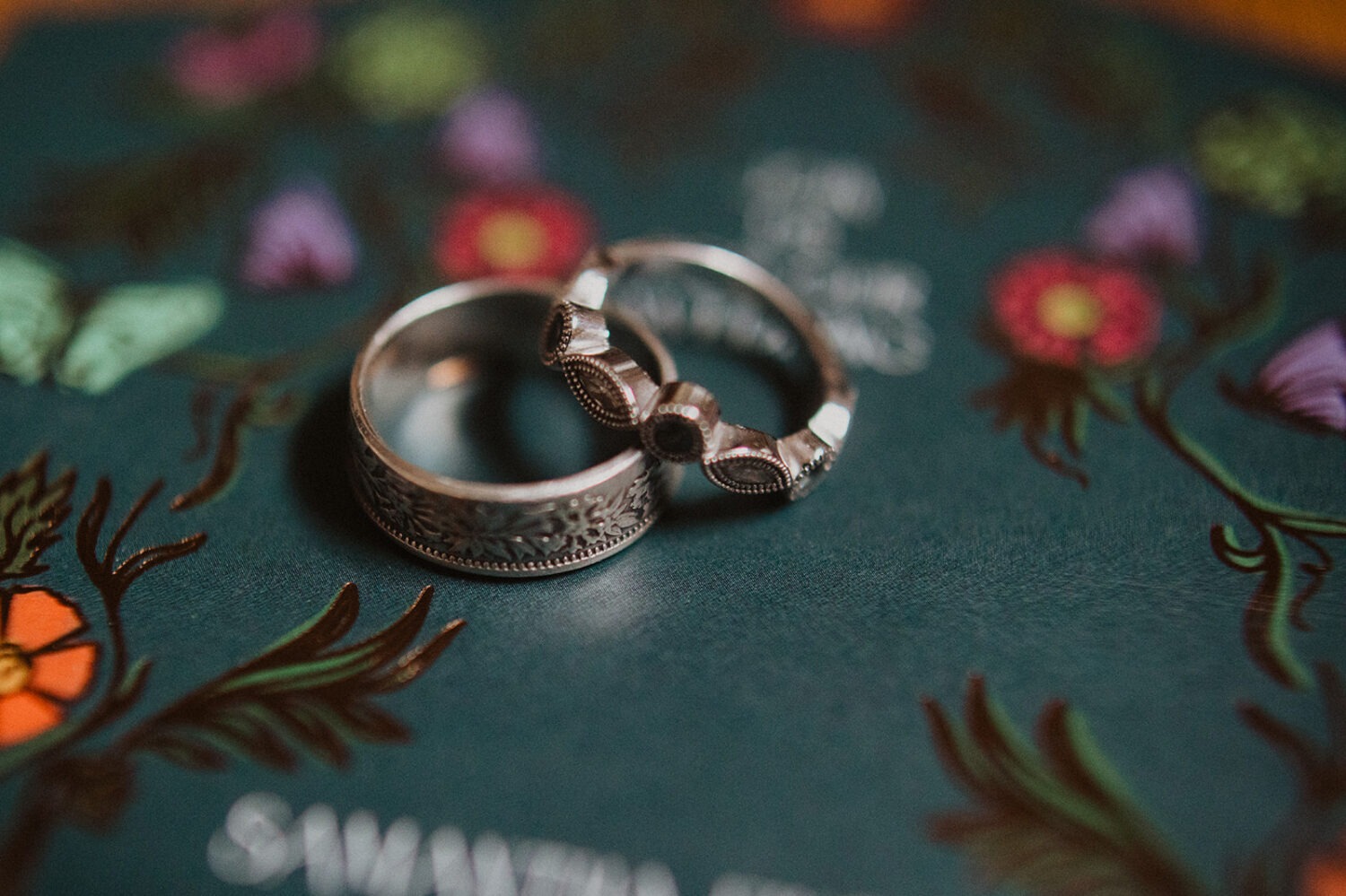 wedding rings sit on wedding invitation 