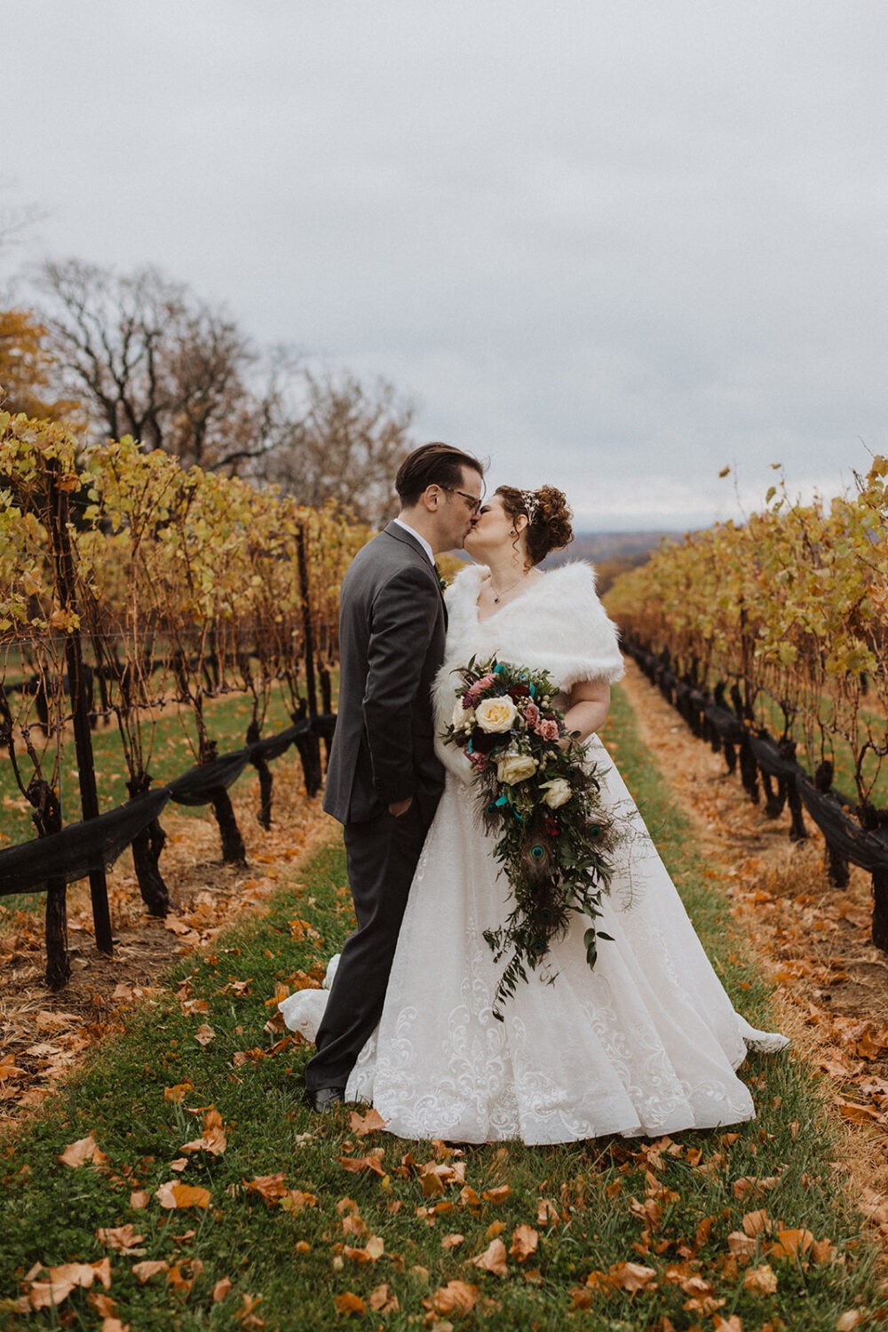 couple holds hands in vineyard at outdoor wedding