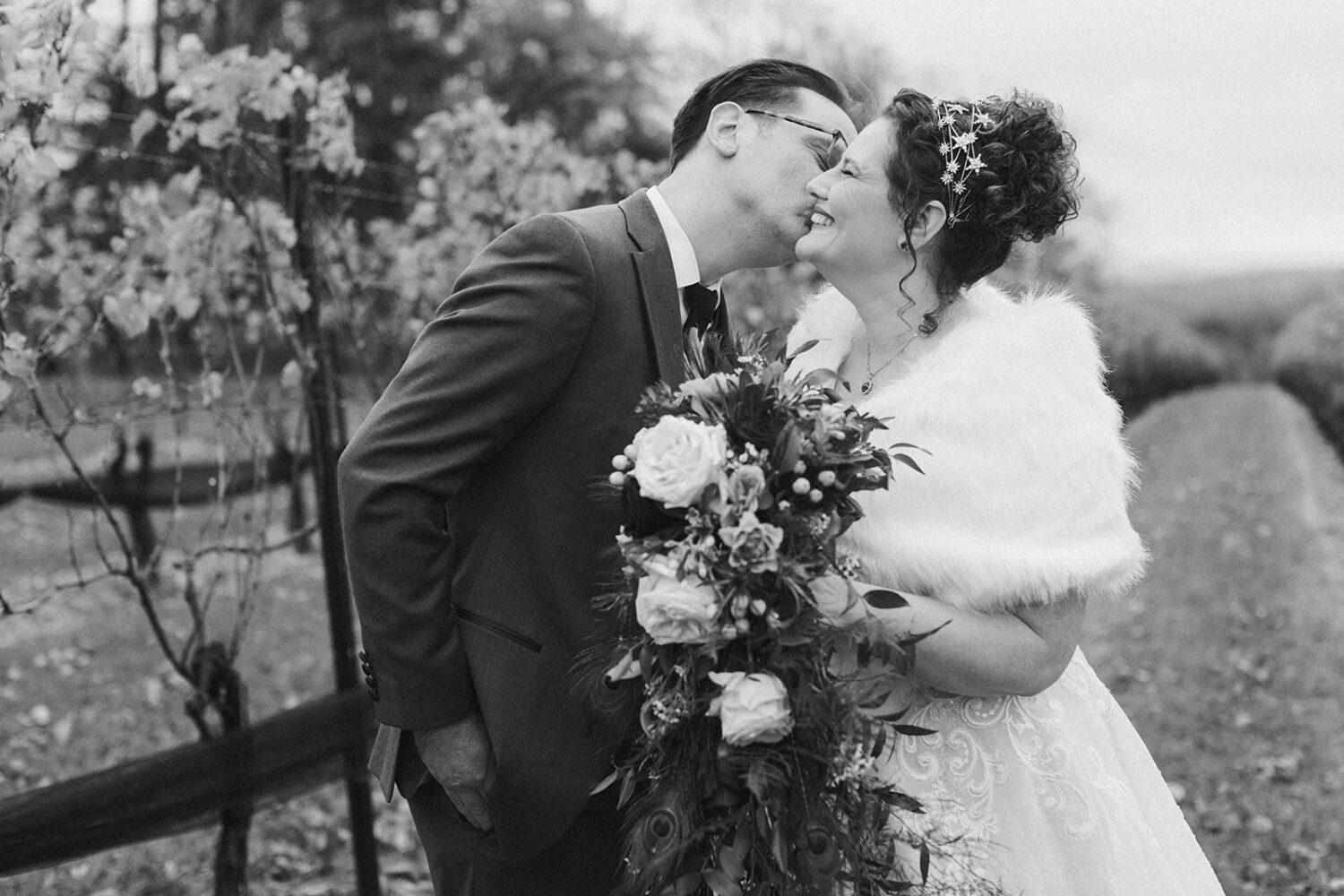 couple kisses at outdoor vineyard wedding following wedding planning tips and advice