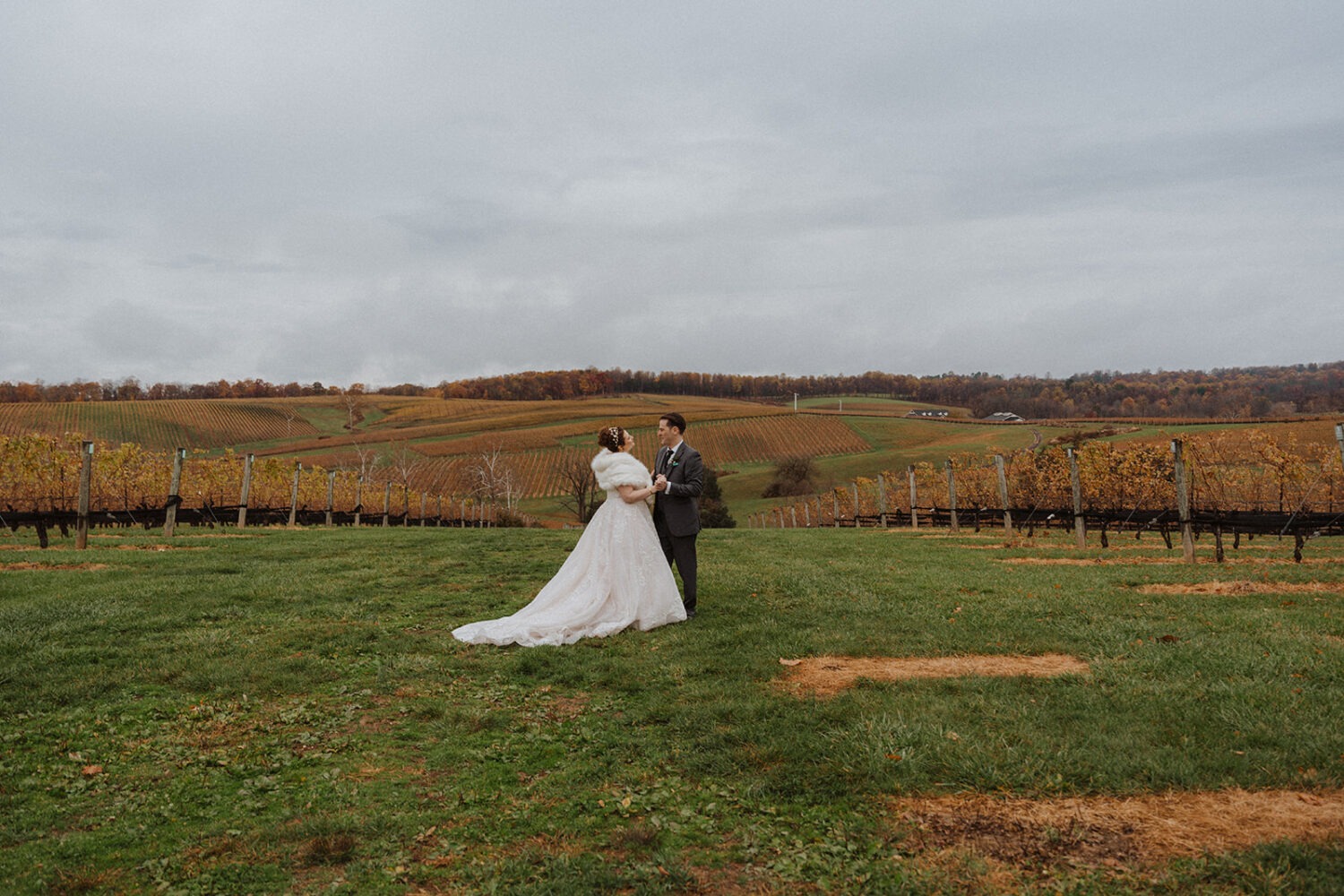 couple stands in field at outdoor wedding 