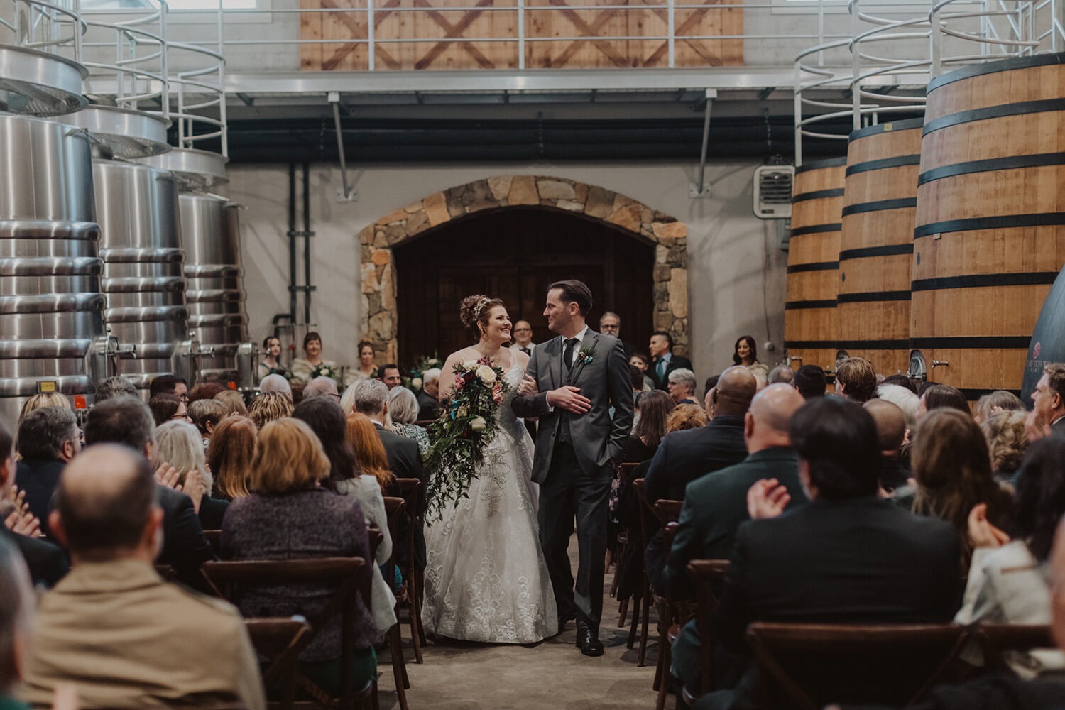 couple walks down aisle together at winery wedding 