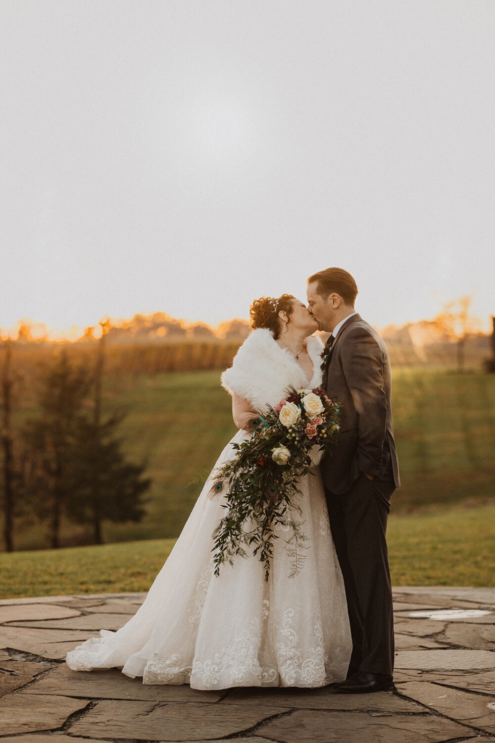 couple kisses together during sunset wedding 