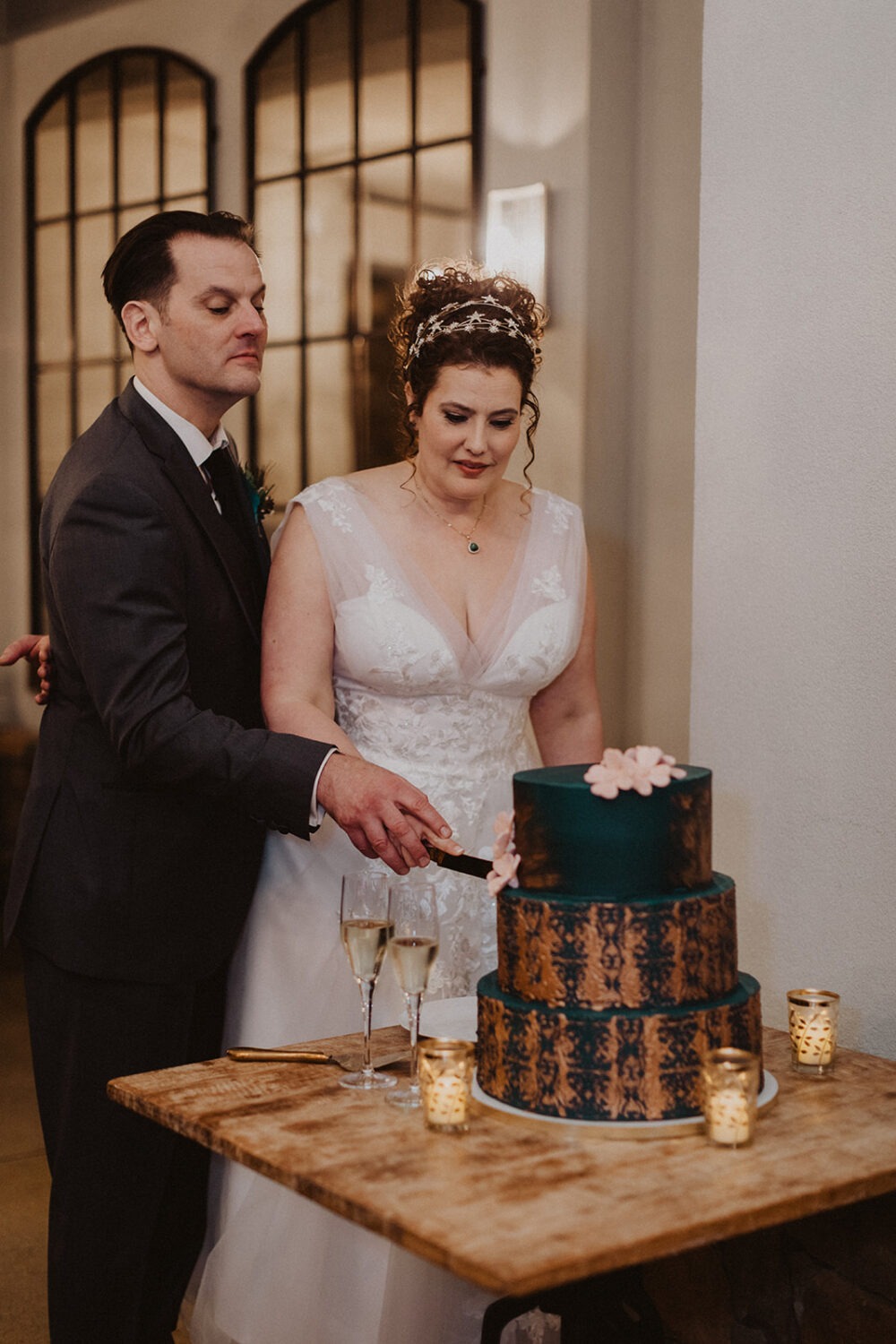 couple cuts green and gold wedding cake