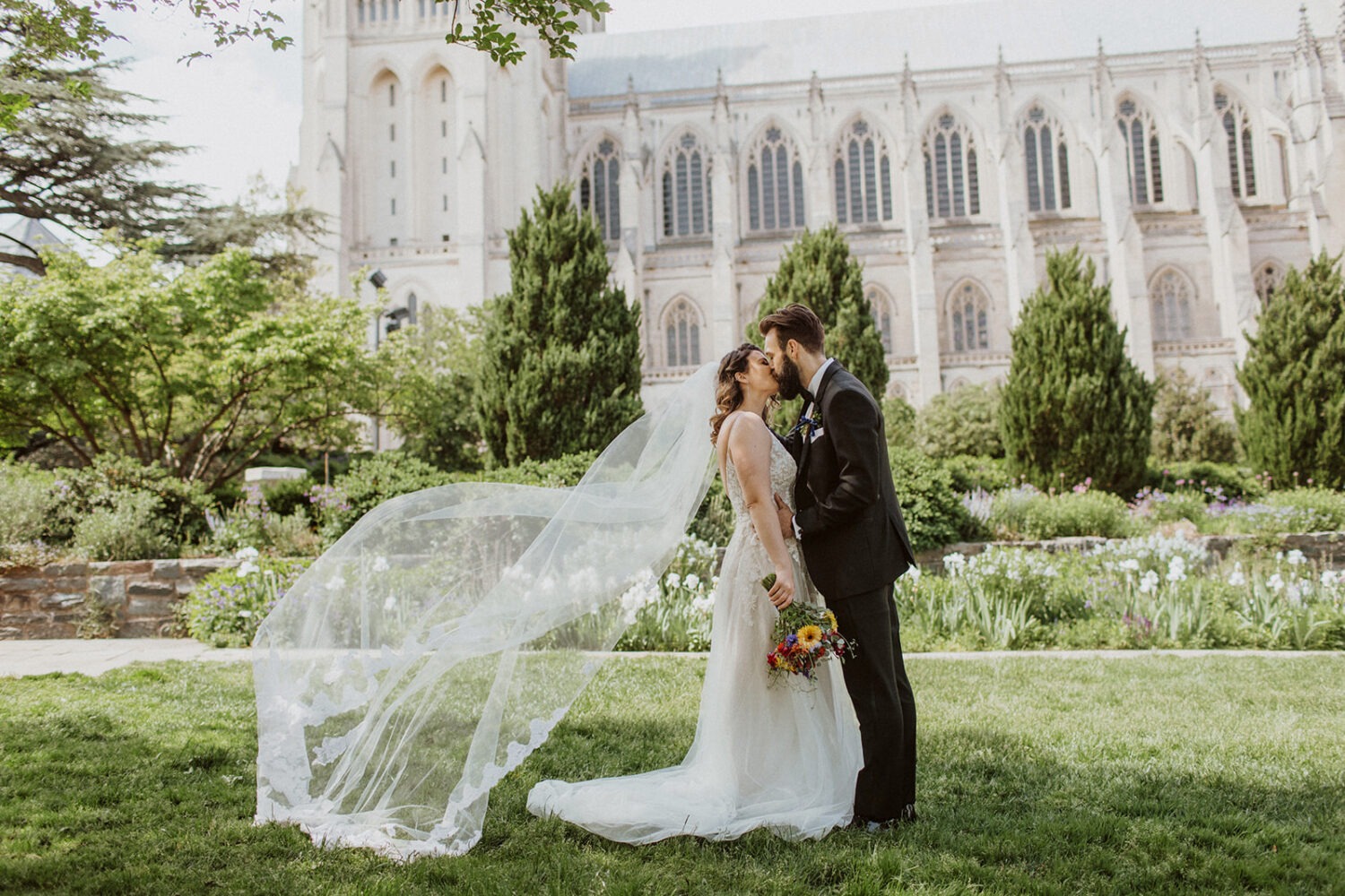 couple kisses at National Cathedral garden wedding