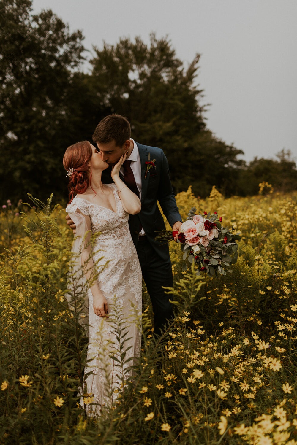 couple kisses in wildflower field at 48 Fields Farm wedding