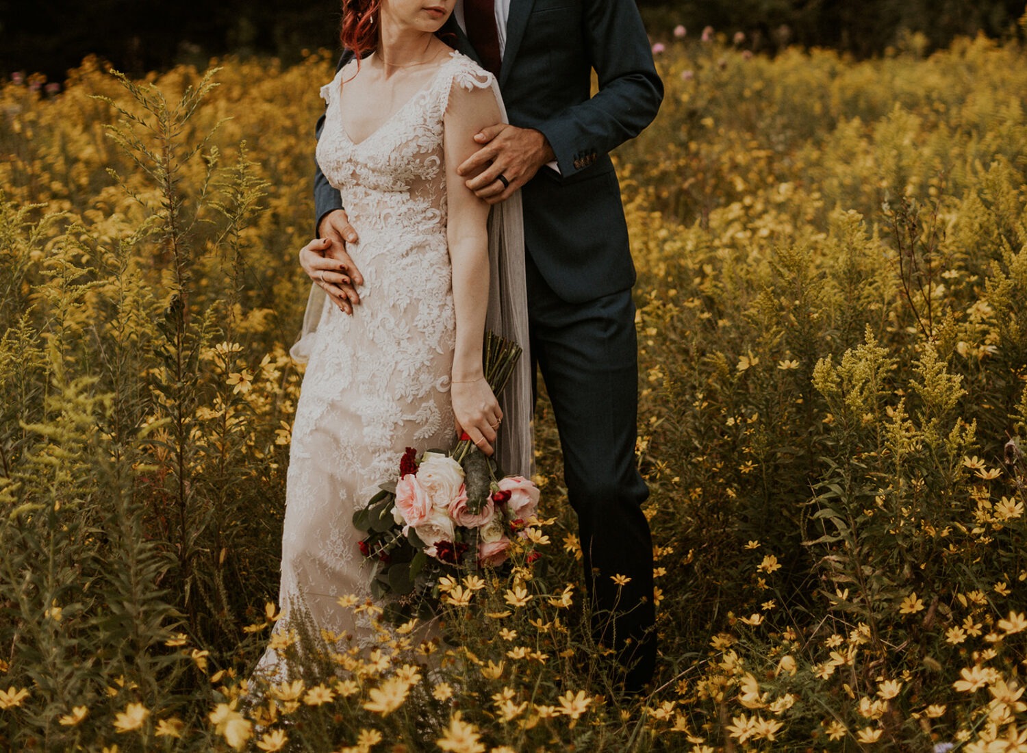 couple poses in wildflower field at 48 Fields Farm wedding