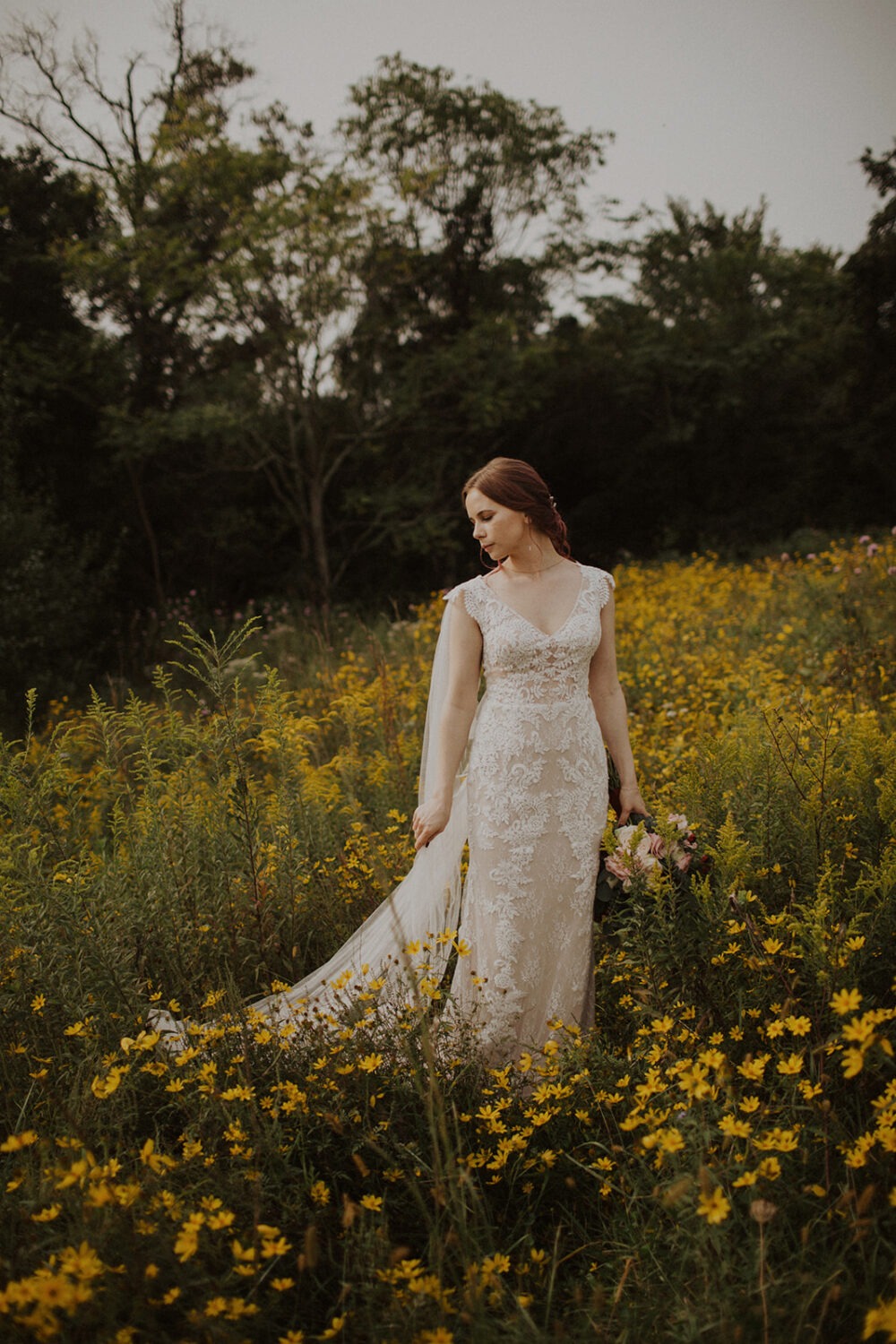 bride poses in wildflower field at 48 Fields Farm wedding
