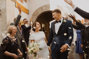 couple exits wedding under flower petals