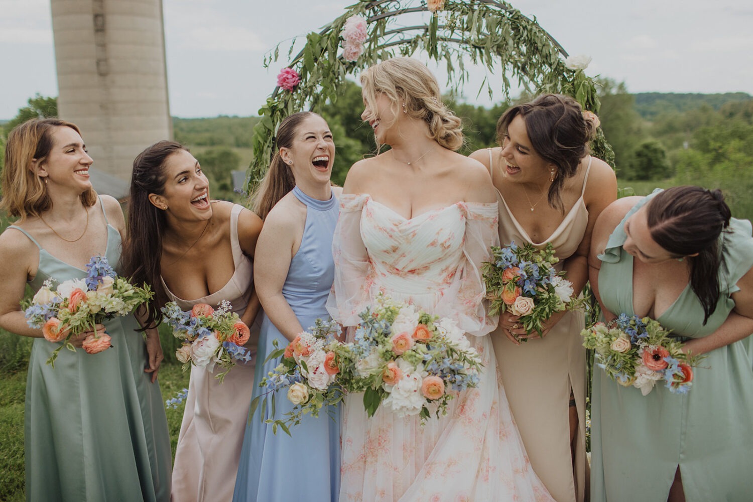 bride poses with bridesmaids holding wedding bouquets