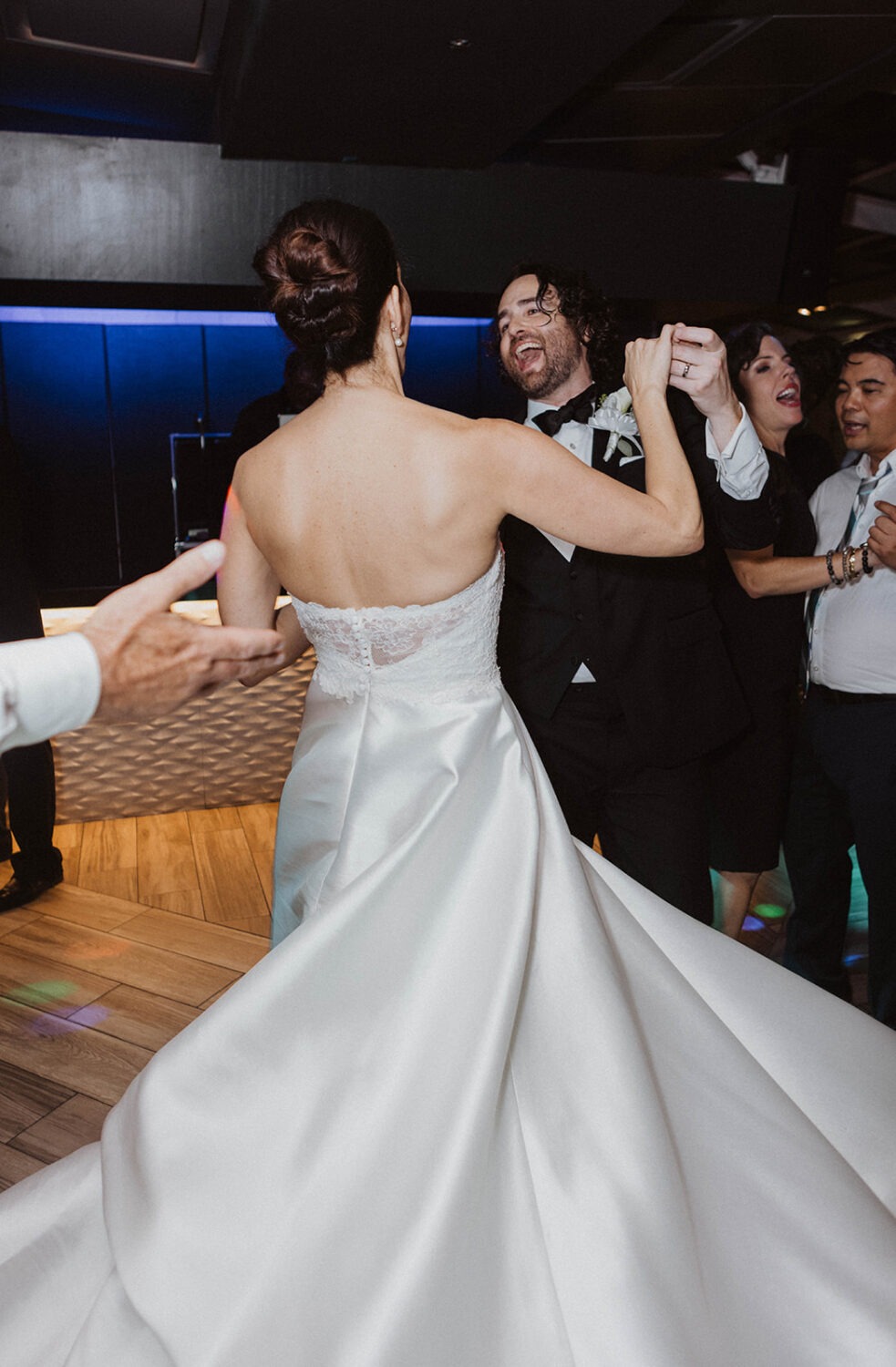 couple laughs together on wedding dance floor