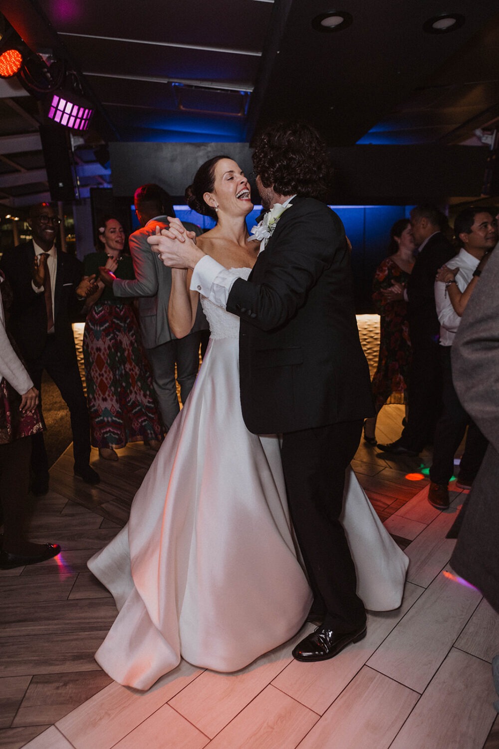 couple laughs together on wedding dance floor