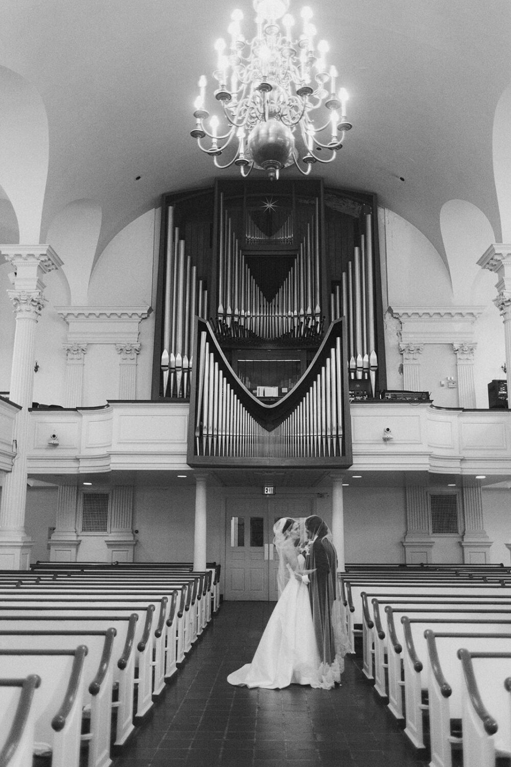 couple kisses at historic church wedding with organ