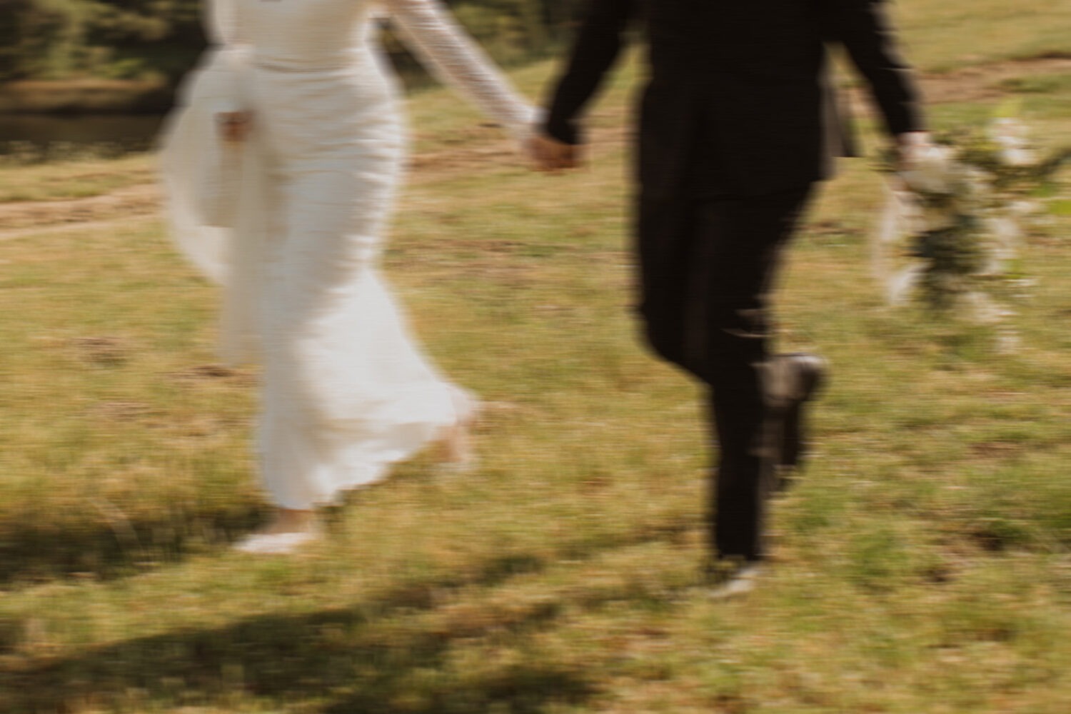 couple runs through field at outdoor wedding