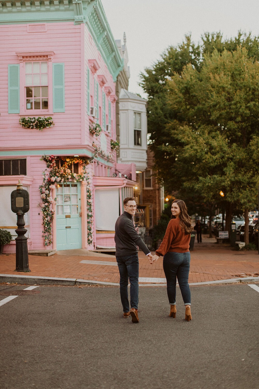 couple walks holding hands at Georgetown engagement session