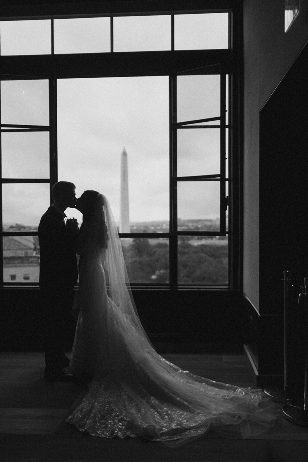 couple kisses with Washington Monument in background