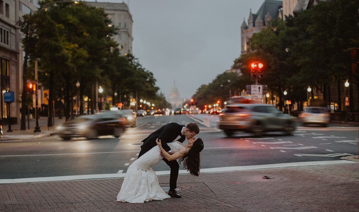 couple kisses in street at Washington DC wedding 