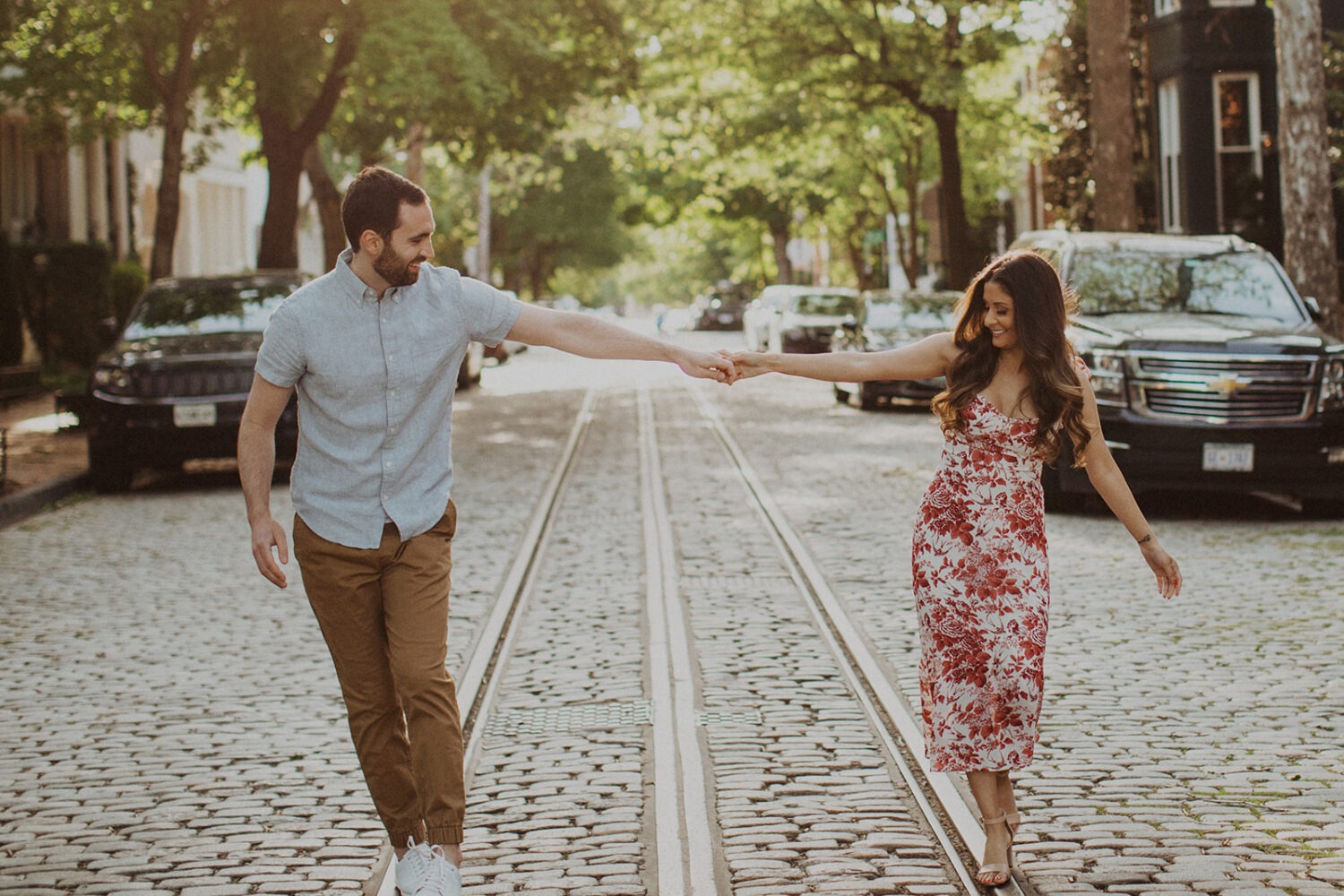 couple walks along city street at Georgetown sunset engagement session