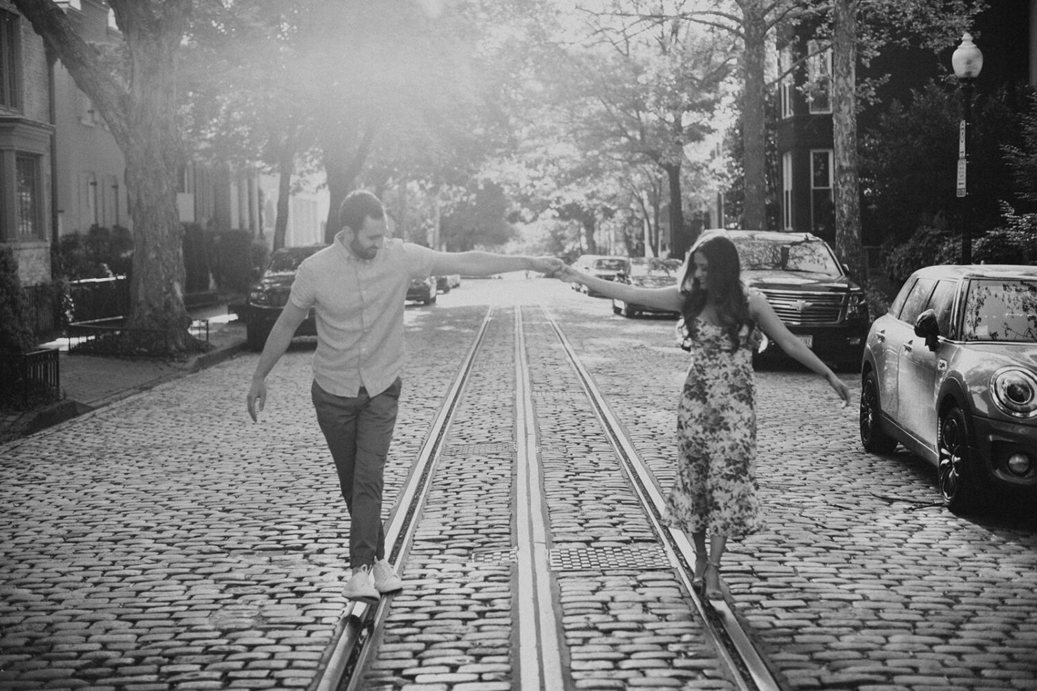 couple walks along city street during Georgetown engagement shoot photos