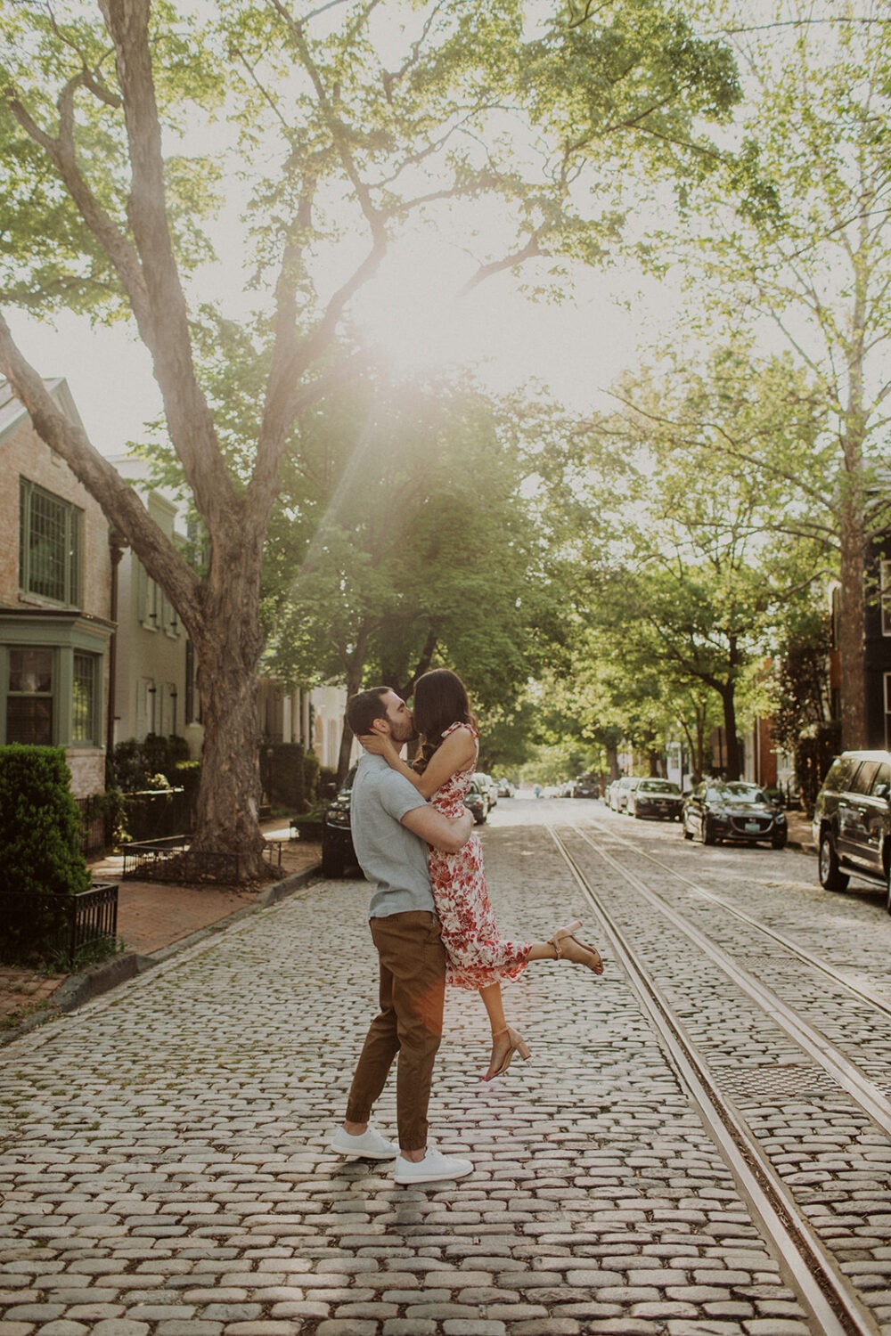 couple embraces on cobblestone Georgetown street 