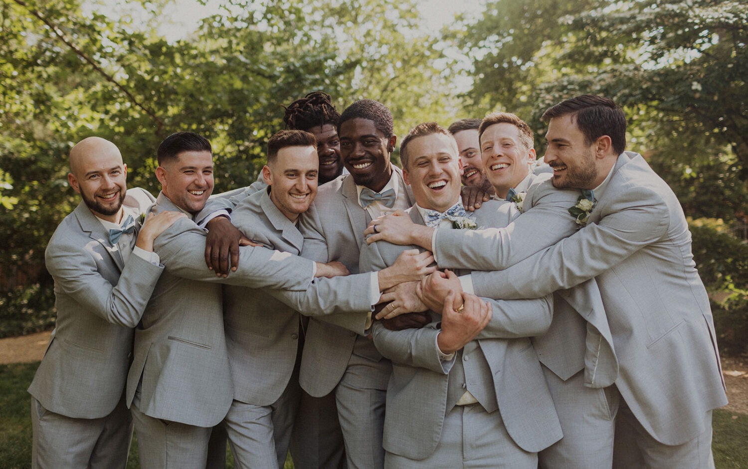 groom embraced by groomsmen on wedding day