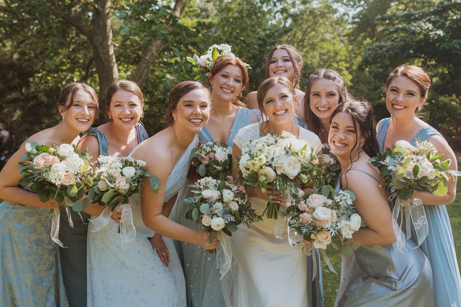 bride poses with bridesmaids holding wedding bouquets