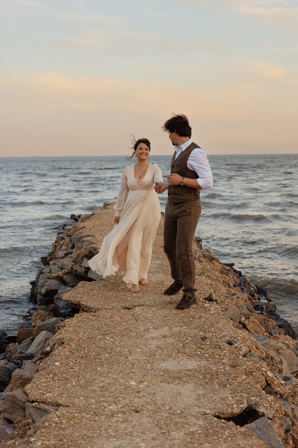 couple walks together at beach engagement session