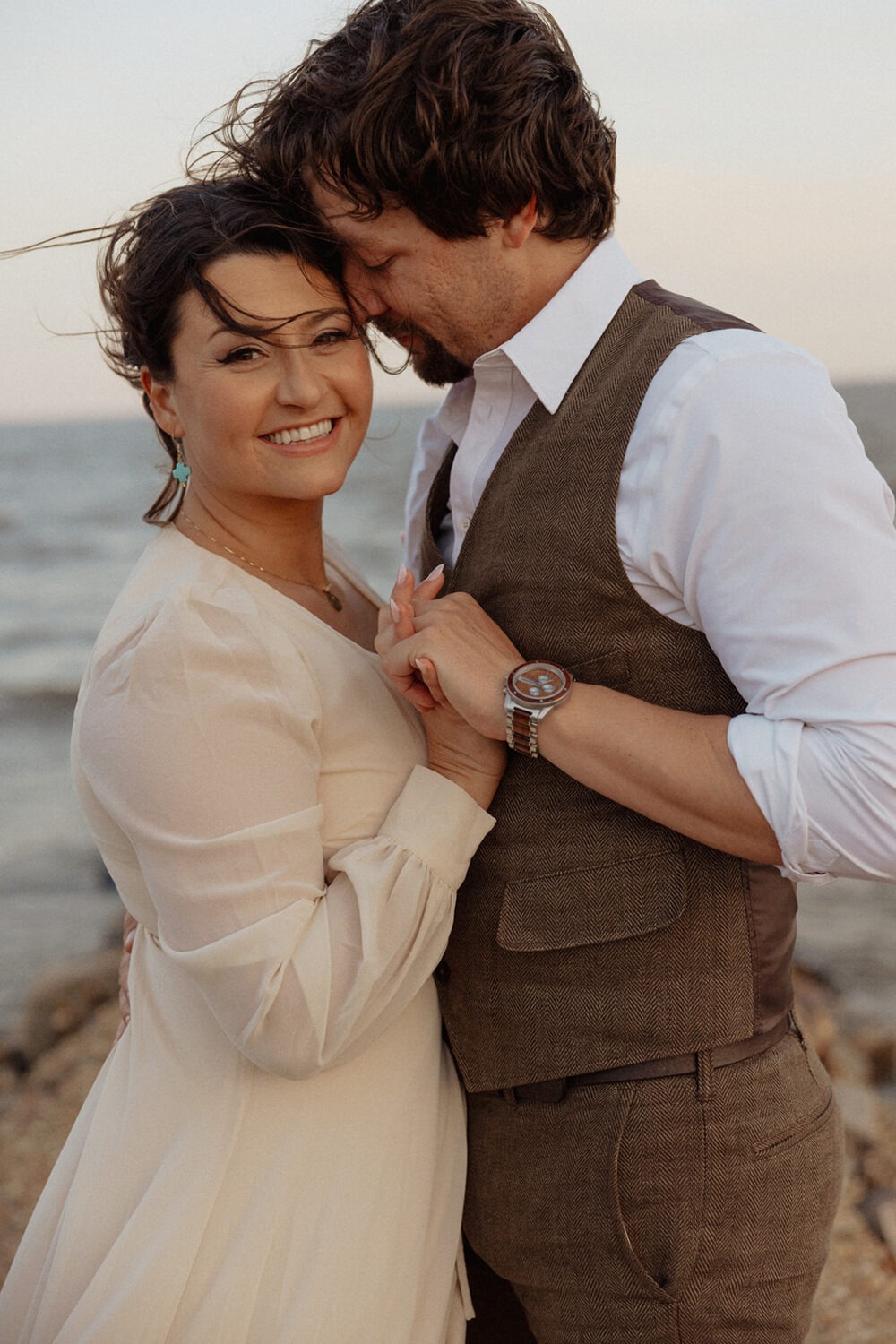 couple embraces at beach engagement photo shoot