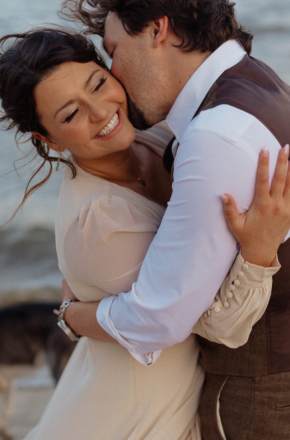 couple embraces at beach engagement session