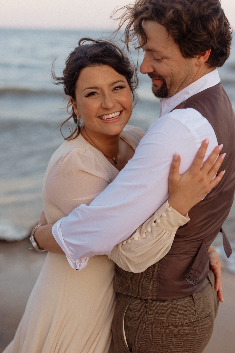 couple embraces at beach engagement session