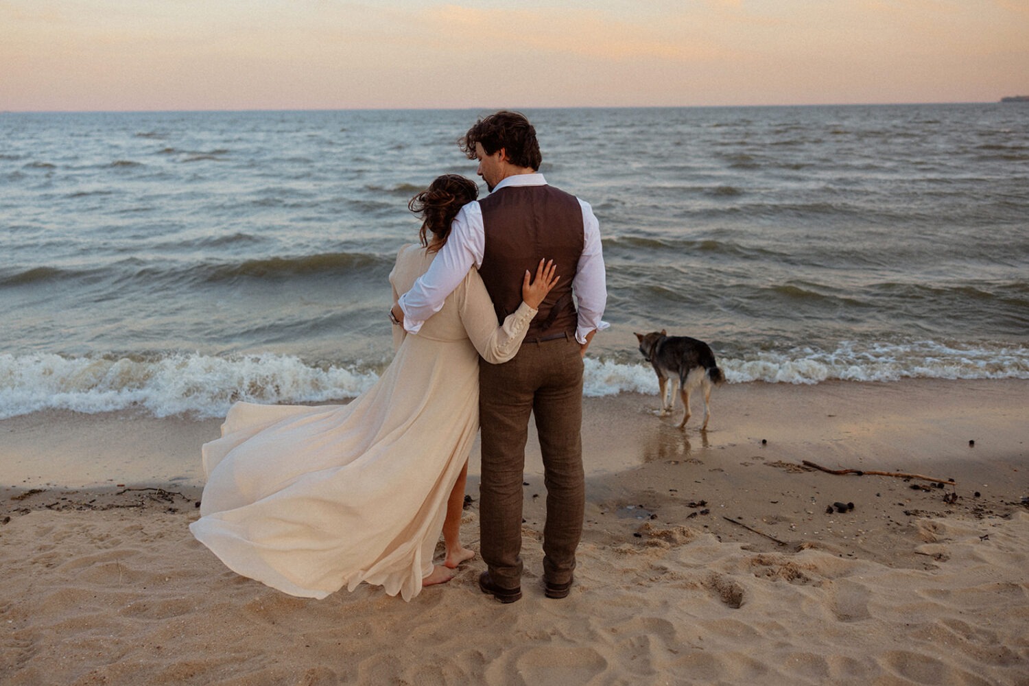 couple embraces at beach engagement session