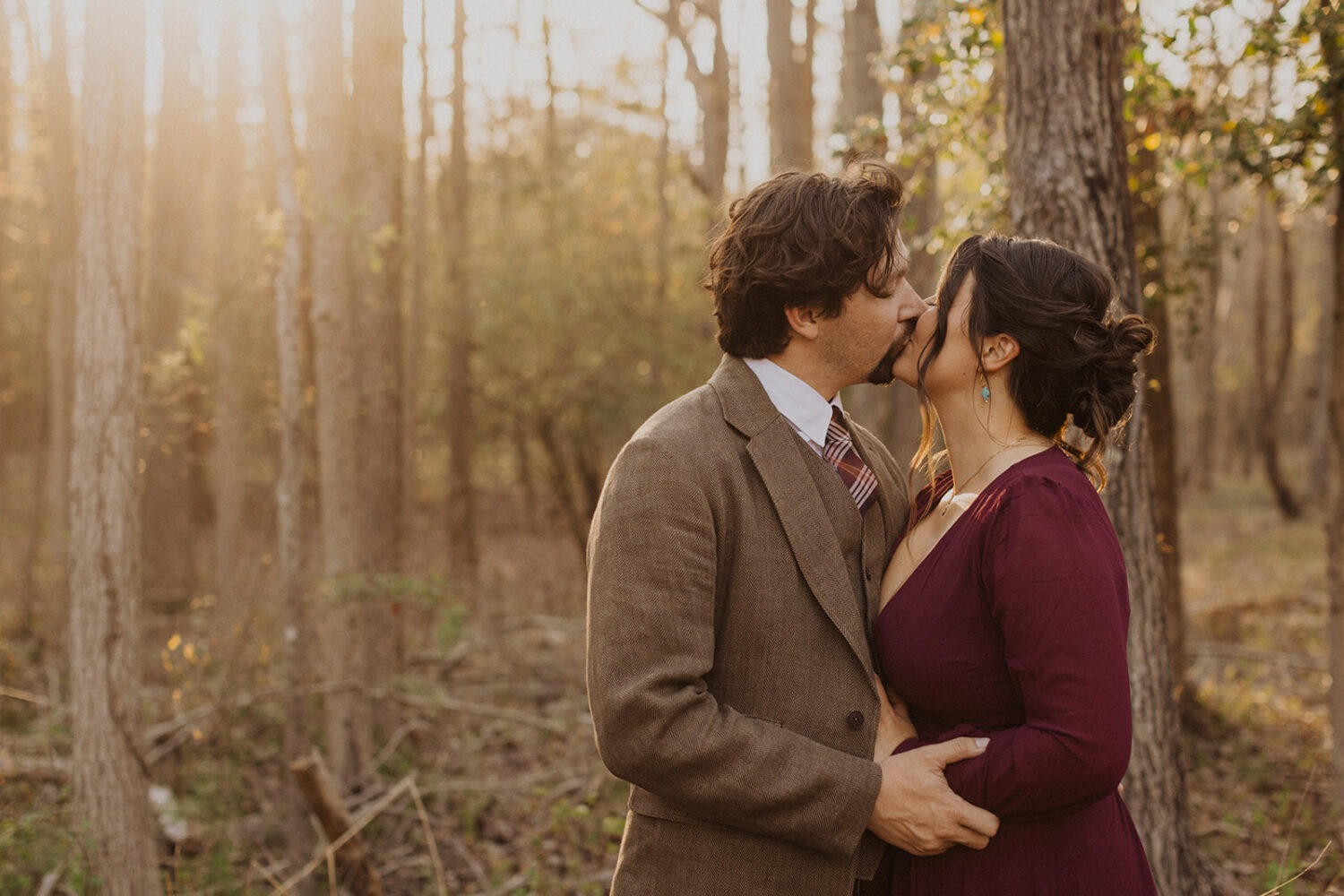 couple kisses at sunset woods photo shoot