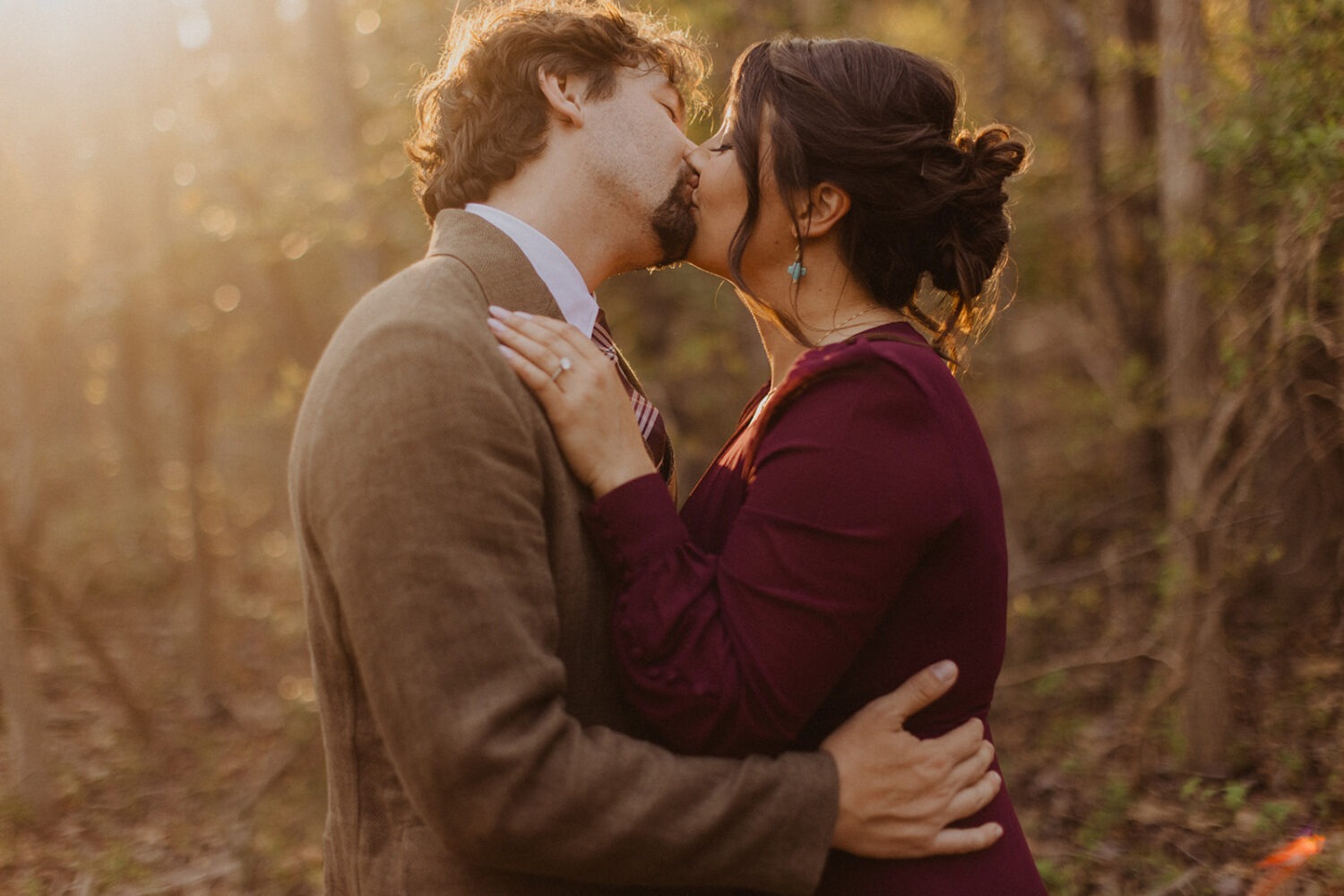 couple kisses at sunset woods photo shoot