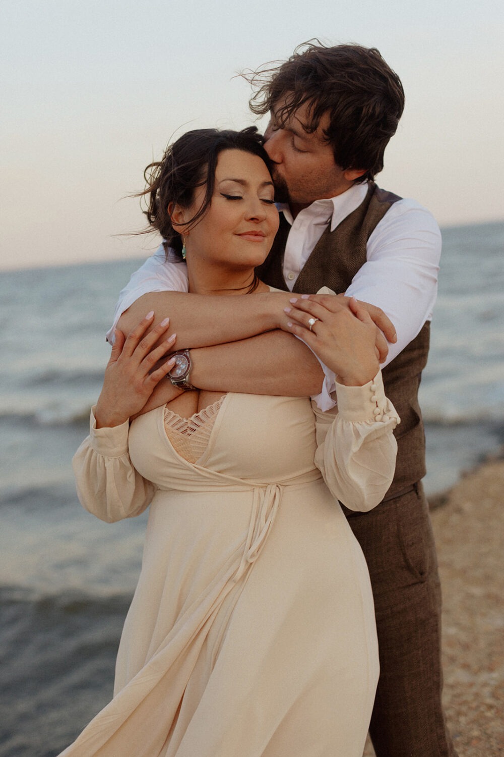 couple embraces at beach engagement session