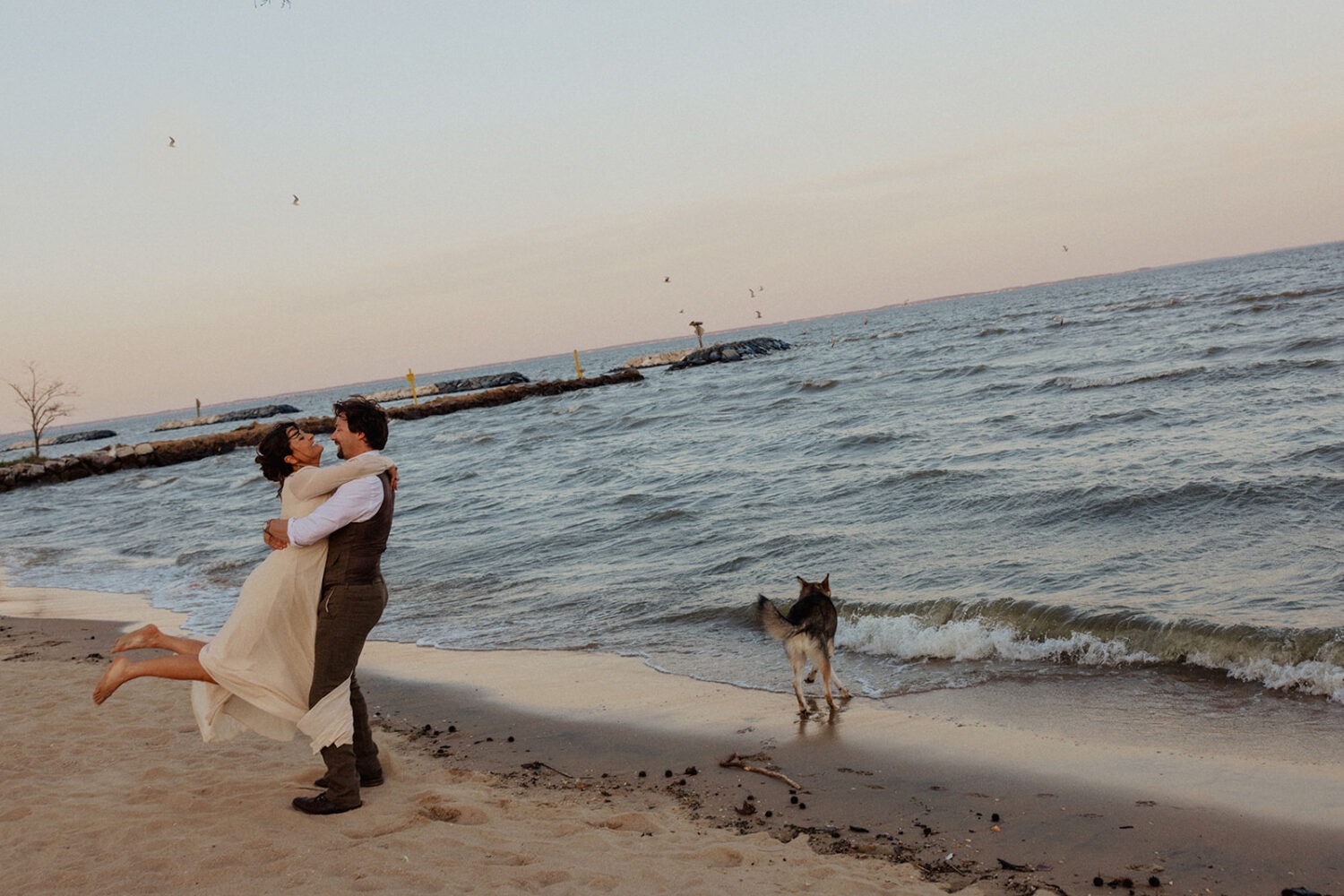 couple twirls at beach engagement session