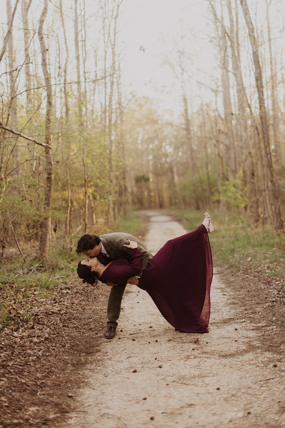 couple kisses at woods engagement session