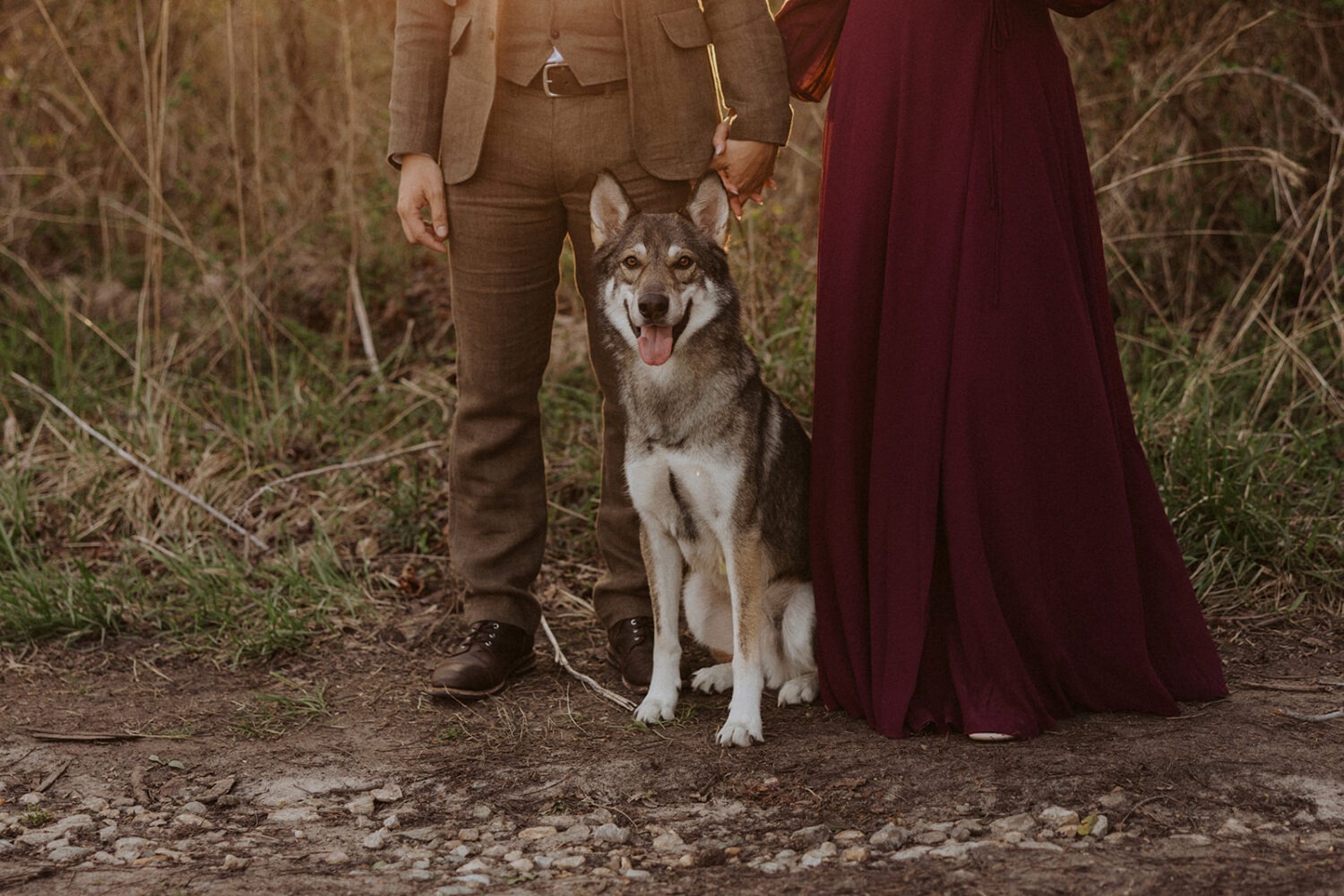 couple poses with dog at outdoor couples shoot