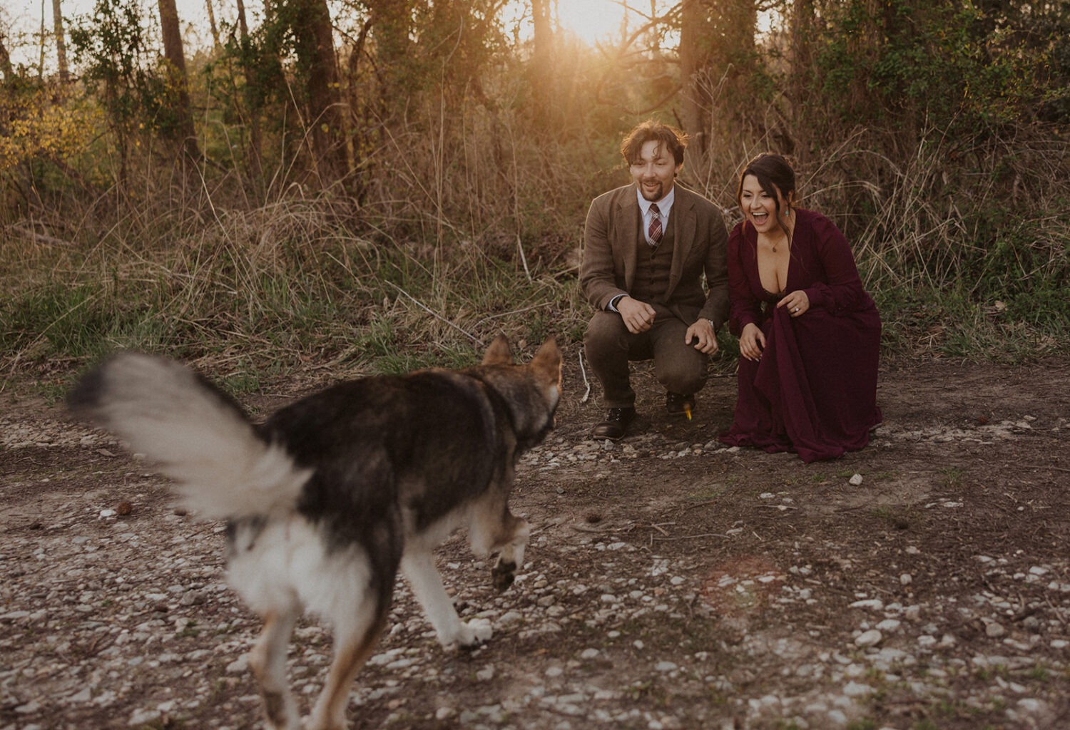 couple poses with dog at outdoor couples shoot