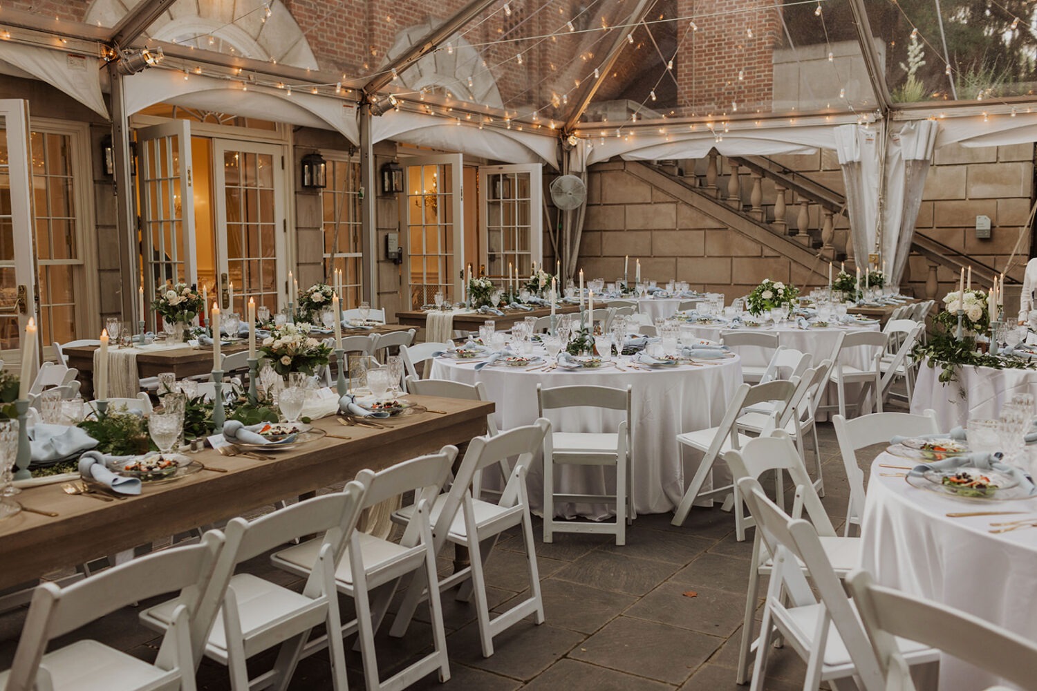 blue and gold table settings at tent garden wedding