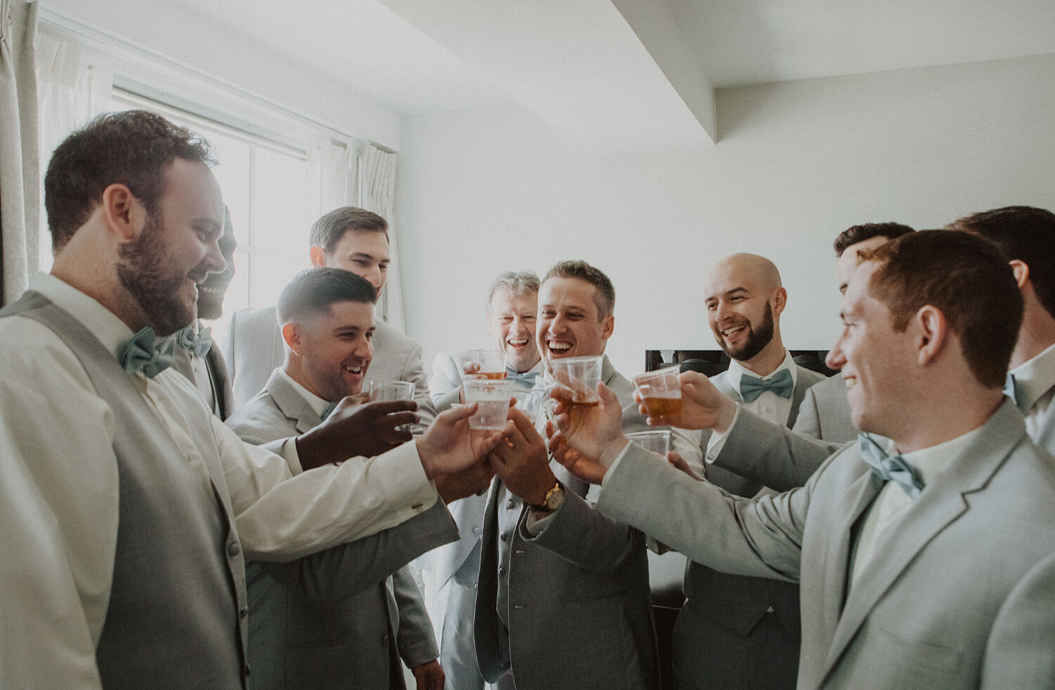 groom cheers with groomsmen 