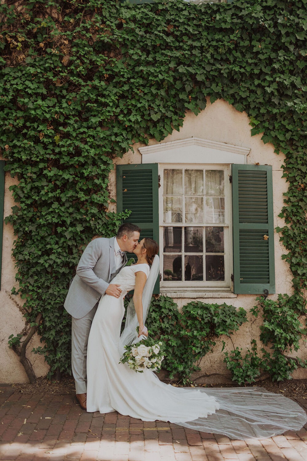 couple poses in front of ivy-covered house at Georgetown Washington DC wedding