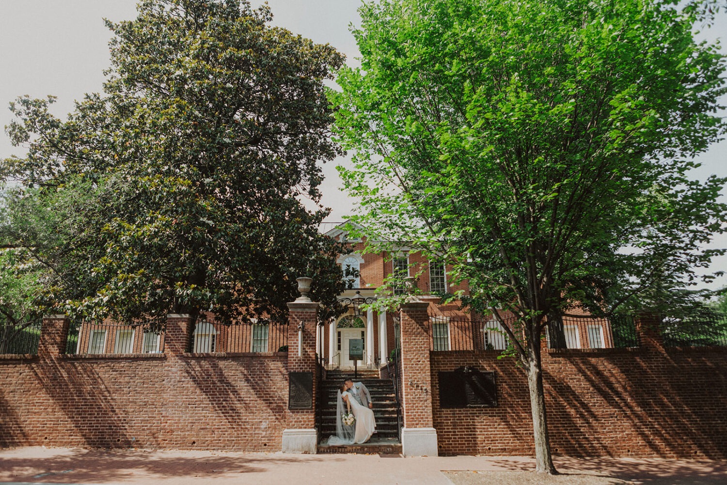 couple kisses in front of venue at Dumbarton House wedding