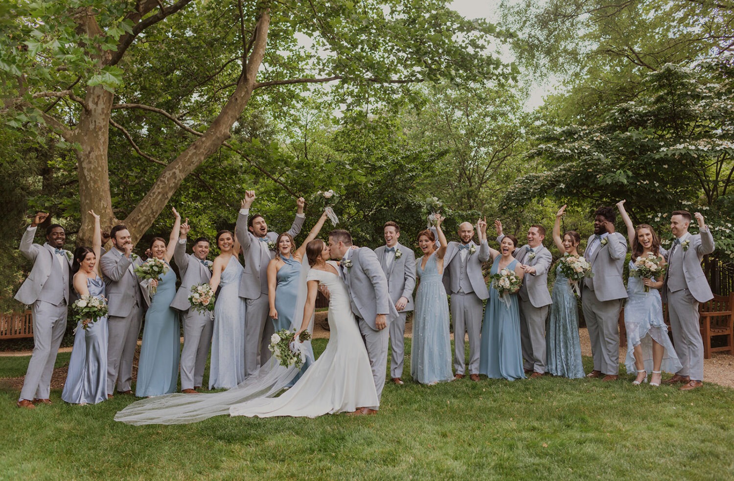 couple poses with wedding party at garden wedding 