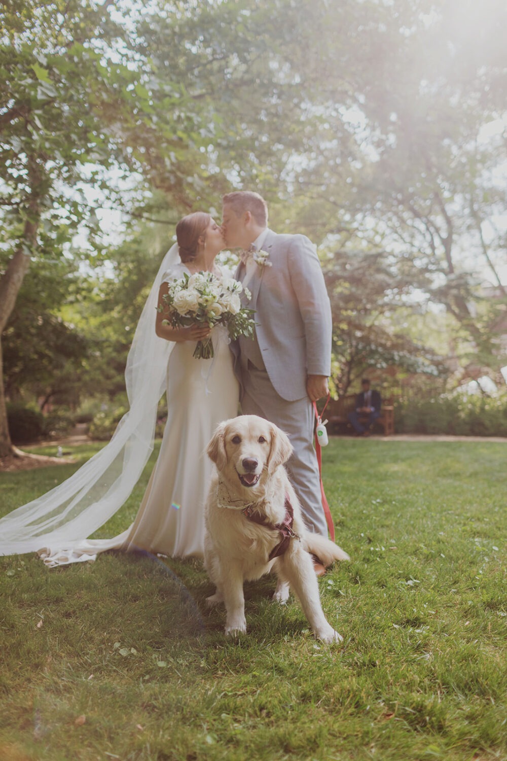 couple poses with pet dog at garden wedding